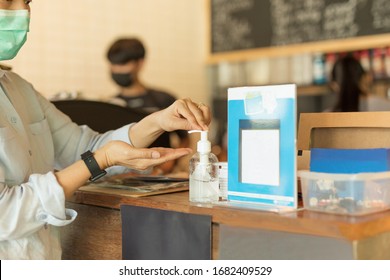 Asian woman wearing protective mask using alcohol antiseptic gel prevent outbreak of Covid-19 in cafe - Powered by Shutterstock