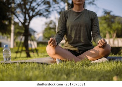 Asian woman wearing sportwear practicing yoga at outside park with sunlight morning. health care and wellness activities. - Powered by Shutterstock