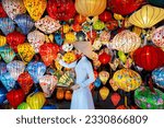 Asian woman wearing vietnam culture traditional and hoi an lanterns at Hoi An ancient town, Vietnam.