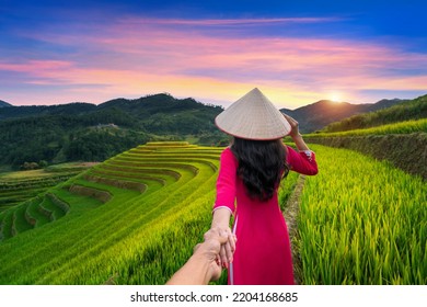 Asian woman wearing Vietnam culture traditional holding man's hand and leading him to rice terraces in Mu Cang Chai, Yen Bai, Vietnam. - Powered by Shutterstock