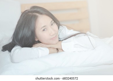 Asian woman wearing white shirt on bed.Soft focus - Shutterstock ID 683240572