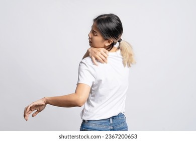 Asian woman wearing white t-shirt with shoulder and back pain standing isolated on white background. - Shutterstock ID 2367200653