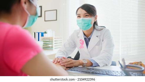 Asian Woman Wears Face Mask To Prevent COVID19 Has Breast Cancer Diagnosis In Hospital - Female Doctor Consulting To Patient In Patience And Putting Hand On Her