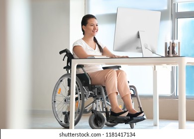 Asian Woman In Wheelchair Working With Computer In Office