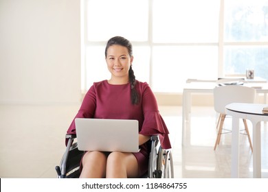 Asian Woman In Wheelchair Working With Laptop In Office