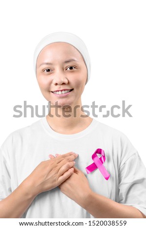Asian woman in a white shirt with pink ribbon isolated over white background. Breast cancer awareness