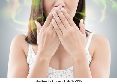 Asian Woman In White Wear Close Her Mouth Against Gray Background, Bad Breath