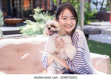 Asian woman who came to a dog cafe with her pet - Shutterstock ID 2248731811
