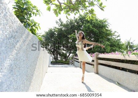 asian woman who wear ballet dress is standing with left foot toe, look left