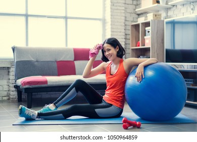 Asian Woman Wiping Her Sweat After A Workout At Home.