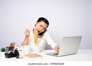 Asian woman working hard overtime eating instant noodles at office. Upset businesswoman busy and hungry overwork. - Powered by Shutterstock