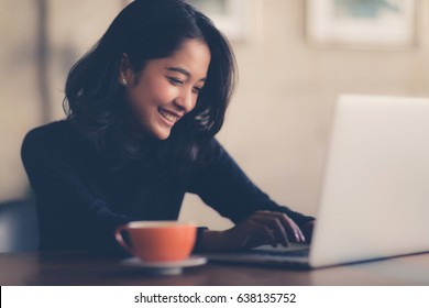 Asian  woman working with her laptop and coffee on desk, Vintage color