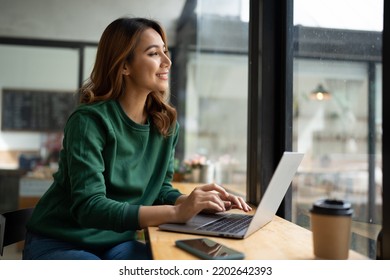 Asian woman working with laptop in coffee shop, business financial concept. - Powered by Shutterstock