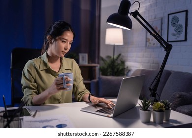 Asian woman working at night, she is holding a coffee cup. Health care concept. - Powered by Shutterstock