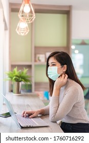 Asian Woman Working On Laptop While Wearing Medical Mask In Co Working Space - New Normal Lifestyle Social Distancing