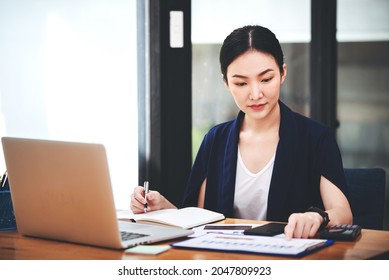 Asian Woman Working Through Laptop. Business Woman Busy Working With Laptop Computer At Office