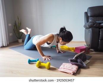 Asian Woman Workout Fitness Knee Push Up Plank Pose Home Yoga Training With Tablet Computer Smart Phone For Healthy Wellness Care On Mat Natural Light Selective Focus