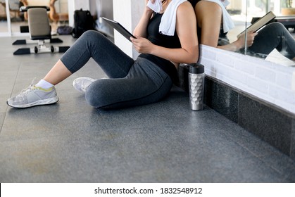 Asian Woman Workout And Working Online Alone At GYM. Social Distancing And New Normal Lifestyle.