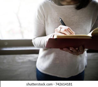 Asian Woman Writing On A Notebook