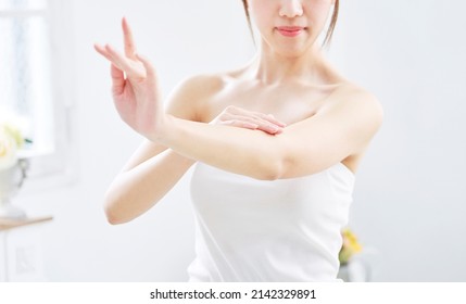 Asian woman's body care of arms, no face