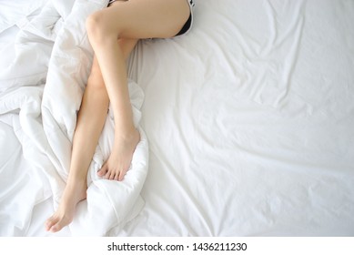 Asian Woman's Legs On The Bed.