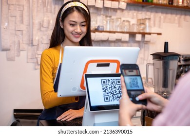 Asian Women Barista Smiling And Using Coffee Machine In Coffee Shop Counter And Asian Customer Women Paying By QR Code Scanning On Mobile Phone At Shop