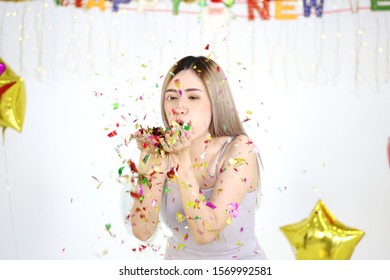 Asian Women Blowing Paper Confetti For A Celebration 