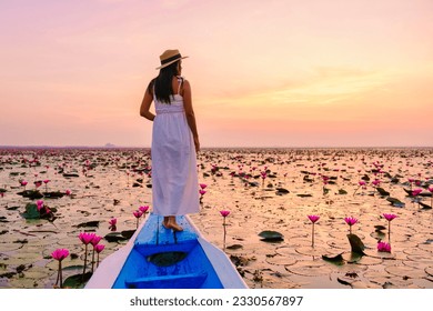 Asian women in a boat at the Beautiful Red Lotus Sea Kumphawapi is full of pink flowers in Udon Thani in northern Thailand. Flora of Southeast Asia. 