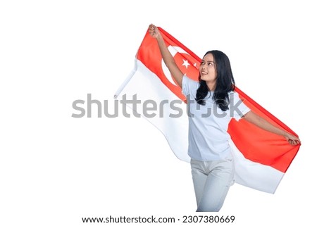Asian women celebrate Singapore independence day on 09 August by holding the Singapore national flag isolated over white background