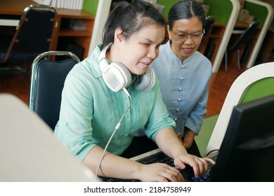 Asian women co-workers in office workplace including person with blindness disability using computer with refreshable braille display assistive device. Disability inclusion at work concepts. - Powered by Shutterstock