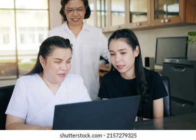  Asian Women Co-workers In Workplace Including Person With Blindness Disability Using Laptop Computer With Screen Reader Program For Visual Impairment People. Disability Inclusion At Work Concepts.