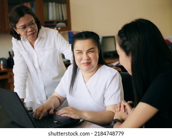 Asian Women Co-workers In Workplace Including Person With Blindness Disability Using Laptop Computer With Screen Reader Program For Visual Impairment People. Disability Inclusion At Work Concepts.