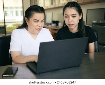 Asian women co-workers in workplace including person with blindness disability using laptop computer with screen reader program for visual impairment people. Disability inclusion at work concepts - Powered by Shutterstock