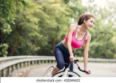 Asian Women Are Cycling In The Park.