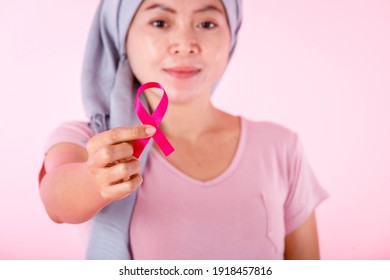 a asian women disease mammary cancer patient in pullover holding pink ribbon isolated on pink blank copy space studio background,healthcare,medicine concept - Shutterstock ID 1918457816