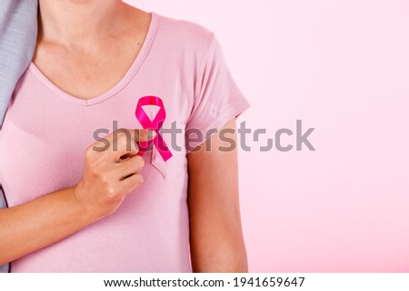 a asian women disease mammary cancer patient in pullover holding pink ribbon isolated on pink blank copy space studio background,healthcare,medicine concept