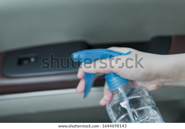 Asian women\
disinfect and clean car\
interior