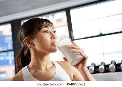 Asian Women Drinking Protein After Training