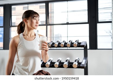 Asian Women Drinking Protein After Training