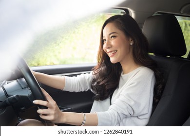 Asian women driving a car and smile happily with glad positive expression during the drive to travel journey, People enjoy laughing transport and relaxed happy woman on roadtrip vacation concept - Shutterstock ID 1262840191