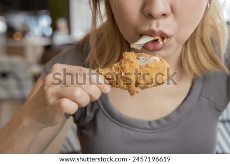 Asian women eating fried chicken in restaurant