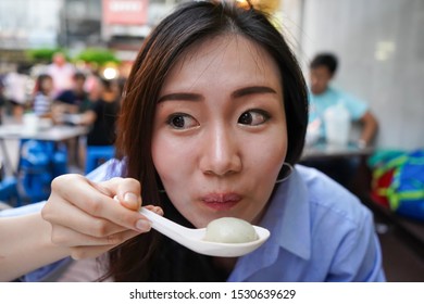 Asian Women Enjoy Eating Delicious Asian Food. A Food Is Very Hot. Closeup Face While Asian Women Eating From The Asian Spoon. With The Reaction While Eating It.