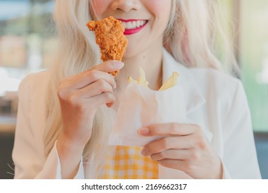 Asian Women Enjoy Eating With French Fries.