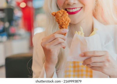 Asian Women Enjoy Eating With French Fries.