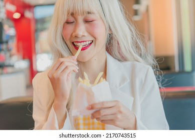 Asian Women Enjoy Eating With French Fries.