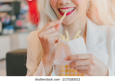 Asian Women Enjoy Eating With French Fries.