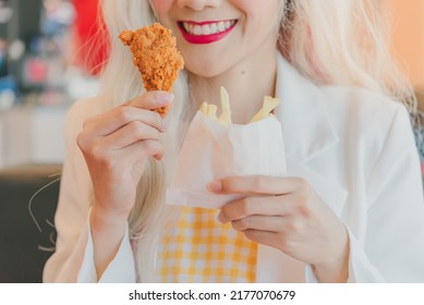 Asian Women Enjoy Eating With French Fries.