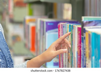 Asian women finding book and reading something at library. People adult female choosing a book on the bookshelf in a library. Education Concept - Shutterstock ID 1767827438