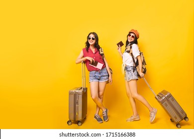 Asian Women Got Tickets To Travel Promotion On Summer, Two Young Girl Traveller Holding Suitcase And Passport In Studio.