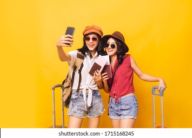 Asian Women Got Tickets To Travel Promotion On Summer, Two Young Girl Traveller Selfie And Holding Suitcase And Passport In Studio.